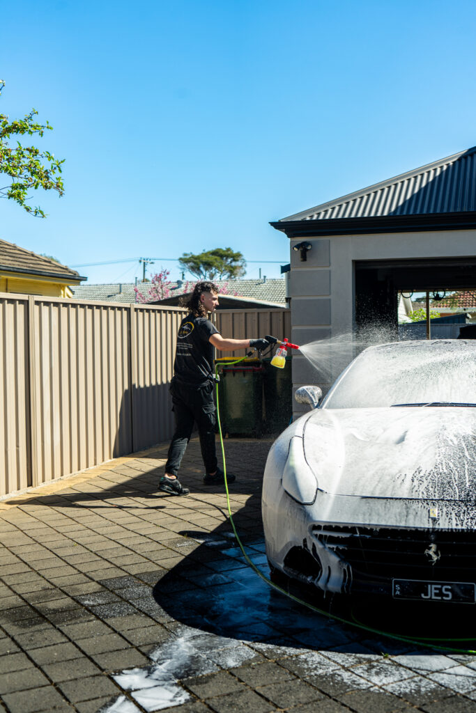 owner of Lusso Autocare doing premium exterior detailing on Ferarri