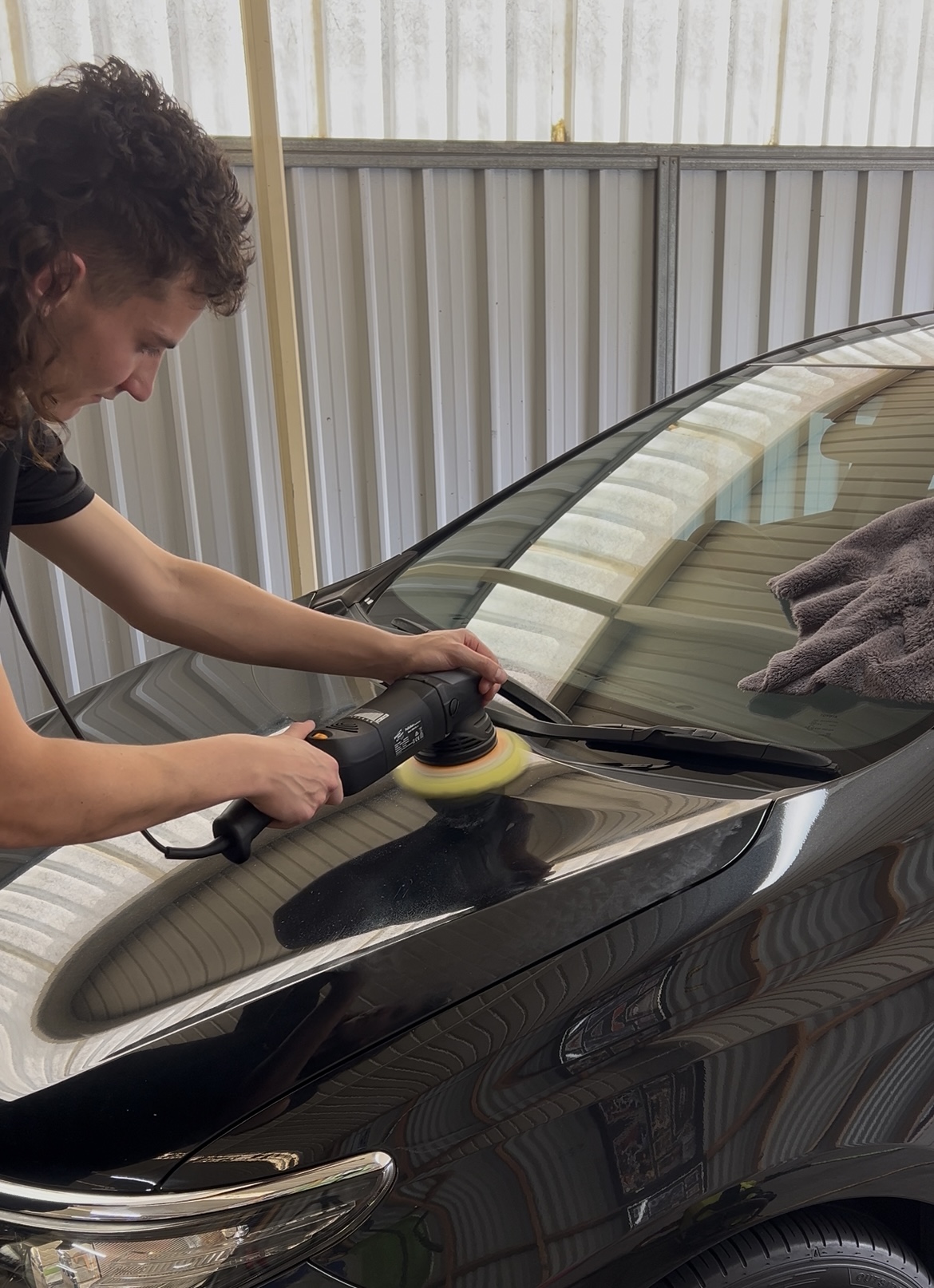 Owner of Lusso Autocare polishing paint for a paint correction